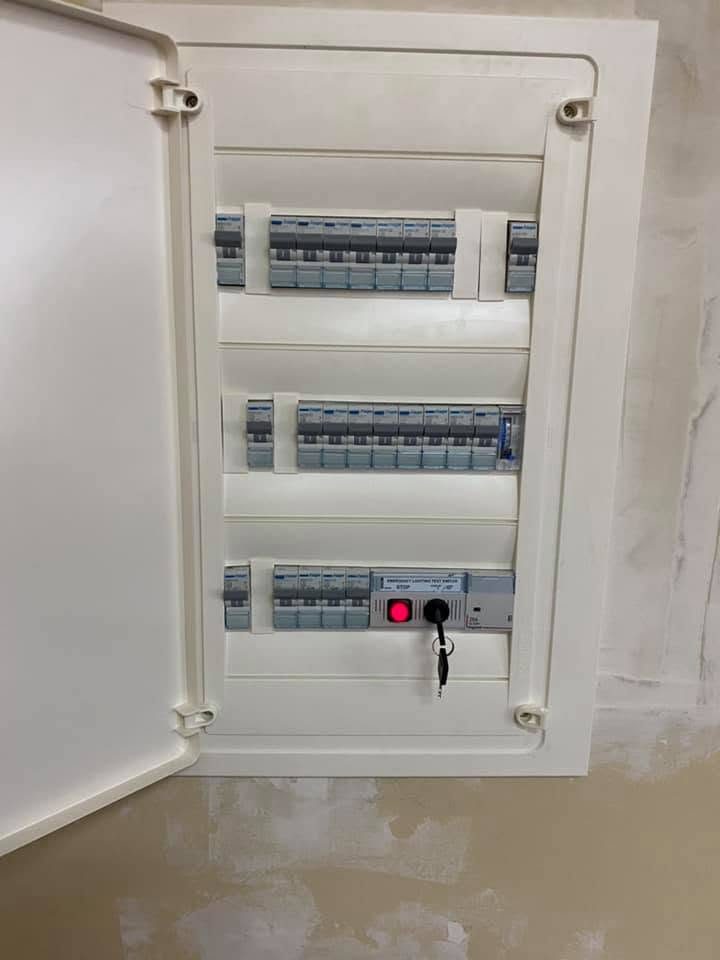 A completed switchboard with its door open and breakers in three rows