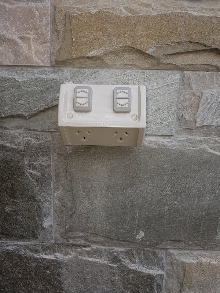 A double power point fixed to a sandstone wall