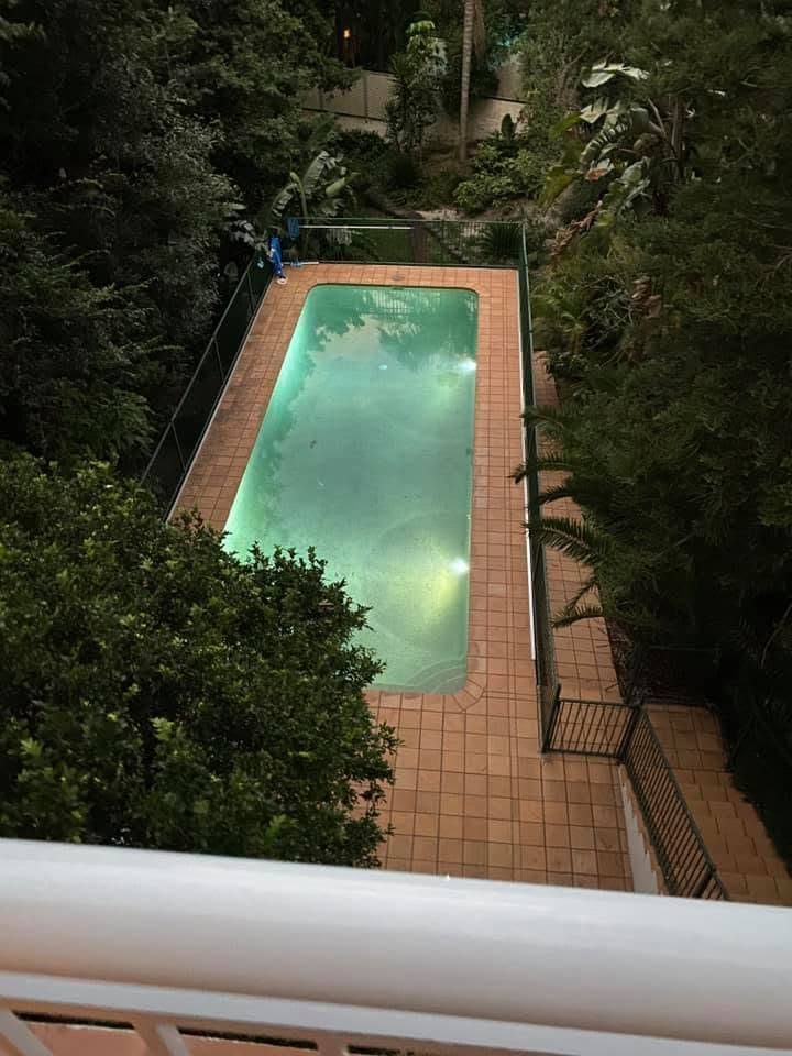 A lap pool lit from underwater, seen from a balcony