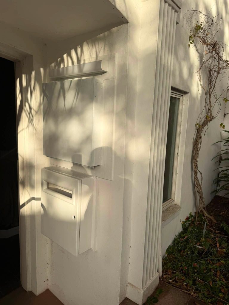 A meter box mounted on the outside wall of a house