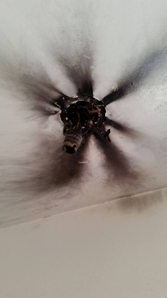 A ceiling scorched black around a failed light fitting