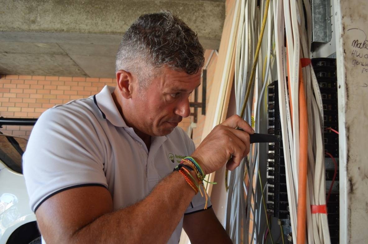 Peter Stafford terminating a bundle of cables at a wall cavity