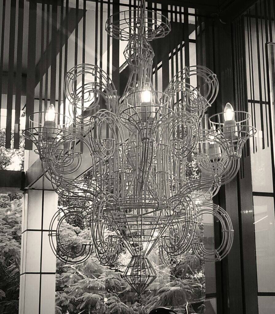 A large glass chandelier hung in a double-height room