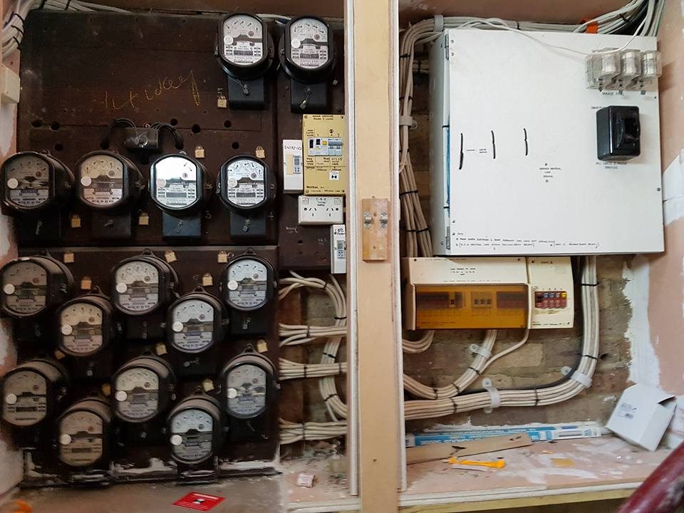 An old meter board with rows of ceramic fuses and analogue meters
