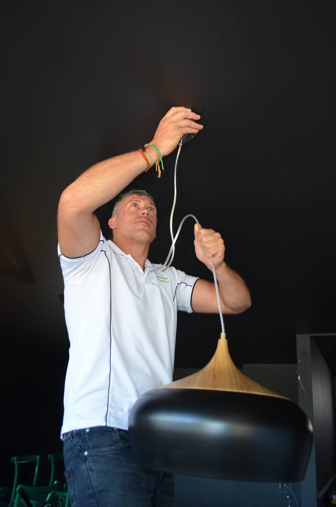 Peter Stafford hanging a large black pendant light