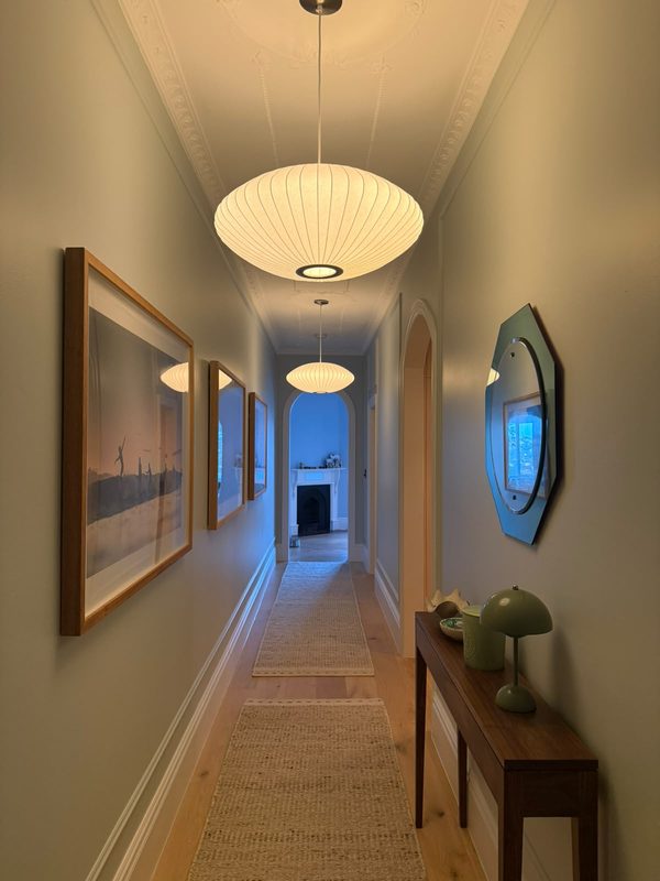 A hallway lit by a row of white paper pendant lights