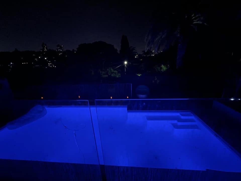 A swimming pool lit blue at night