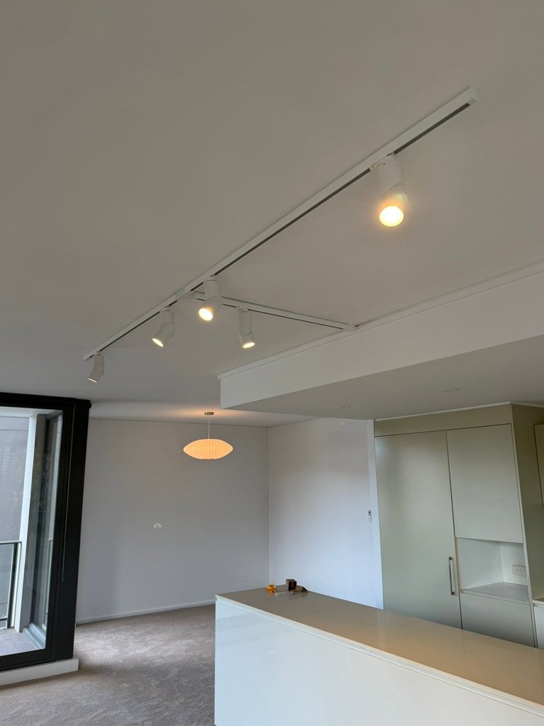 Track lighting across the ceiling of an open-plan room